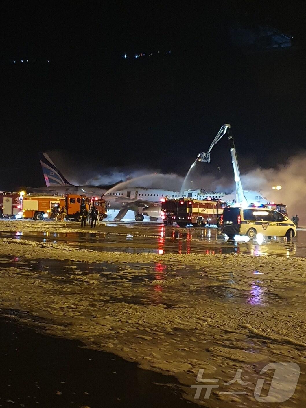 본문 이미지 - 28일 오후 10시 26분쯤 김해공항에서 홍콩행 에어부산 항공기 꼬리 부분에서 불이 나 소방당국이 진화 작업을 펼치고 있다.(독자제공) 