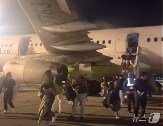 본문 이미지 - 28일 오후 부산 강서구 대저동 김해공항에서 홍콩행 에어부산 항공기에서 화재가 발생해 탑승 승객들이 비상탈출을 하고 있다. 승객 169명, 승무원 7명 모두 대피했으며 화재는 진압됐다. (독자 제공)2025.1.29/뉴스1