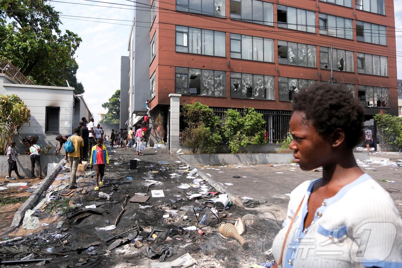 28일(현지시간) 콩고민주공화국 수도 킨샤사에서 시위대 습격으로 파손된 르완다 대사관을 한 여성이 바라보고 있다. ⓒ 로이터=뉴스1 ⓒ News1 류정민 특파원