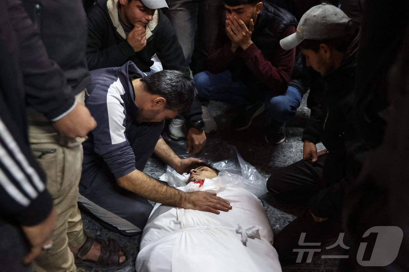 팔레스타인 가자 지구 병원에서 주민들이 하마스와 전쟁 중인 이스라엘 군의 포격을 받아 숨진 희생자를 안고 오열하고 있다. <자료사진> ⓒ AFP=뉴스1 ⓒ News1 우동명 기자
