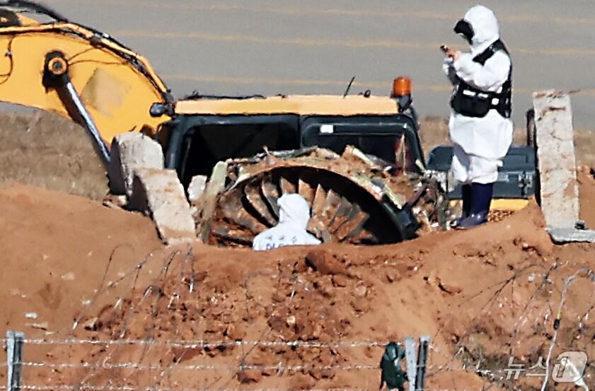 본문 이미지 - 제주항공 여객기 참사 엿새째인 3일 오후 전남 무안국제공항 참사 현장에서 국과수 관계자들이 로컬라이저&#40;방위각시설&#41; 둔덕에 파묻힌 엔진을 살펴보고 있다. 2025.1.3/뉴스1 ⓒ News1 오대일 기자
