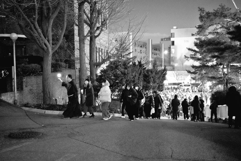 본문 이미지 - 꼰벤뚜알 프란치스코 수도회 신부님이 응원봉을 들고 집회 참여자들에게 화장실을 안내해주는 장면. (엑스 이용자 닉네임 '무리야난 @muriyanan' 갈무리)