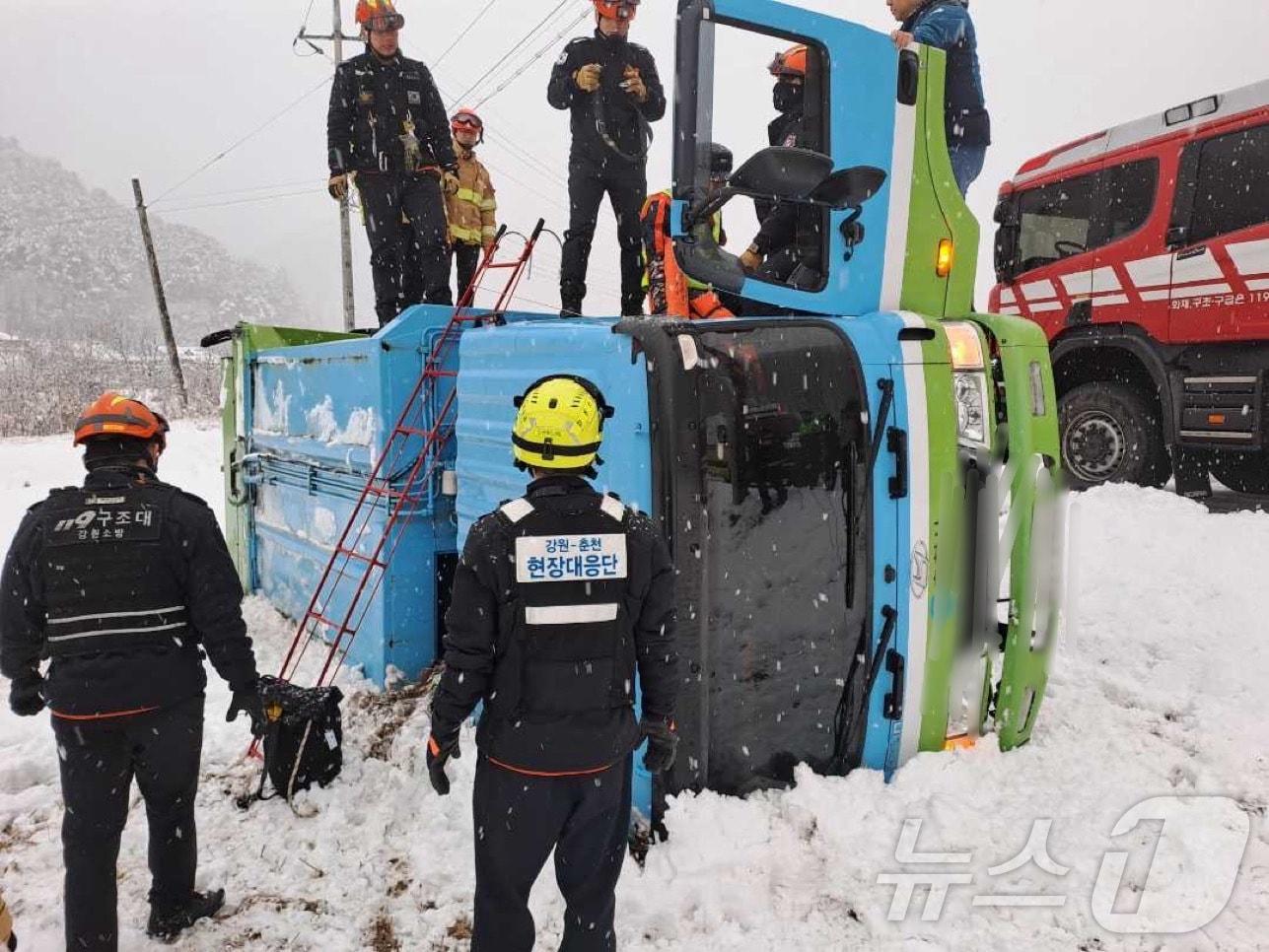 본문 이미지 - 눈길에 전도된 5톤 쓰레기수거 차량.(강원도소방본부 제공)