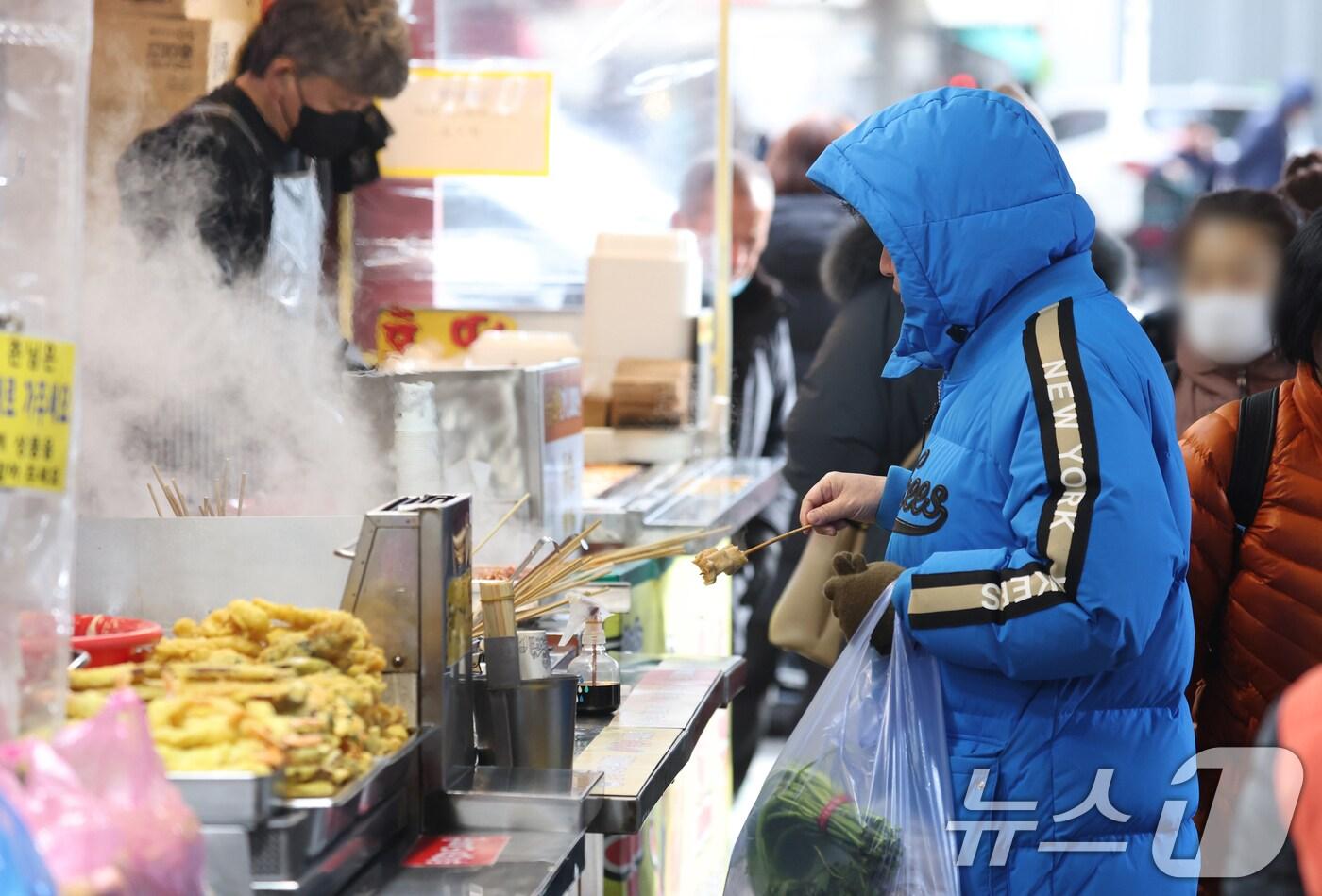 본격적인 한파가 시작된 7일 오후 경기 수원시 팔달구 수원화성 팔달문 인근에서 한 시민이 어묵을 먹고 있다. 2025.1.7/뉴스1 ⓒ News1 김영운 기자