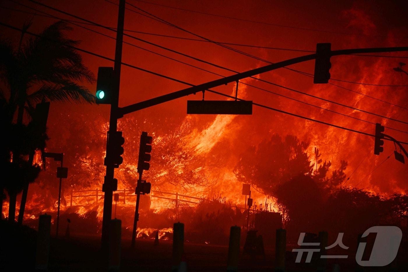 7일 &#40;현지시간&#41; 펠리세이즈 산불이 발생한 캘리포니아주 로스앤젤레스 인근의 퍼시픽팰리세이즈에 있는 태평양 연안 고속도로가 불길에 휩싸인 모습이 보인다. 2025.01.08 ⓒ AFP=뉴스1 ⓒ News1 우동명 기자