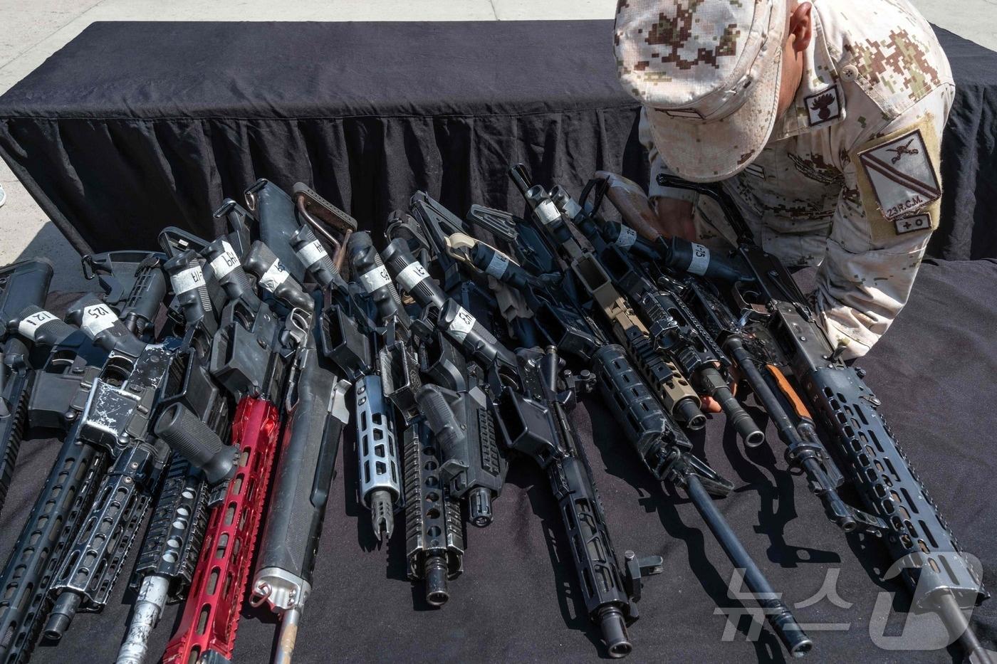 본문 이미지 - 멕시코 바하 캘리포니아주 티후아나에 있는 제2군사구역 본부에서 한 군인이 압수한 총기를 검사하고 있다. 24.08.08 ⓒ AFP=뉴스1 ⓒ News1 김예슬 기자