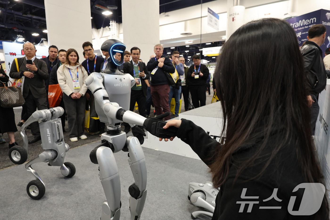 세계 최대 정보기술&#40;IT&#41;·가전 전시회 &#39;CES 2025&#39; 개막일인 7일&#40;현지시간&#41; 미국 네바다주 라스베이거스 컨벤션센터&#40;LVCC&#41;에 마련된 중국 유니트리 부스에서 휴머노이드 로봇 G1이 관람객과 악수하고 있다. 2025.1.8/뉴스1 ⓒ News1 신웅수 기자