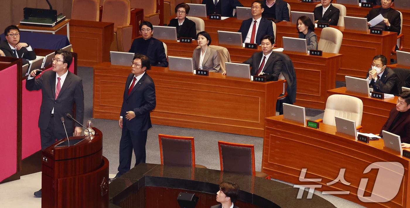 본문 이미지 - 국민의힘 김상욱 의원(오른쪽 두번째 단상)을 비롯한 의원들이 8일 오후 서울 여의도 국회에서 열린 제420회국회(임시회) 제4차 본회의에서 쌍특검법(내란·김건희 여사 특검법) 등 8개 법안 재의의 건이 부결되면서 야당 의원들이 퇴장하자 우원식 국회의장에 항의하는 권성동 원내대표를 바라보고 있다. 2025.1.8/뉴스1 ⓒ News1 김민지 기자