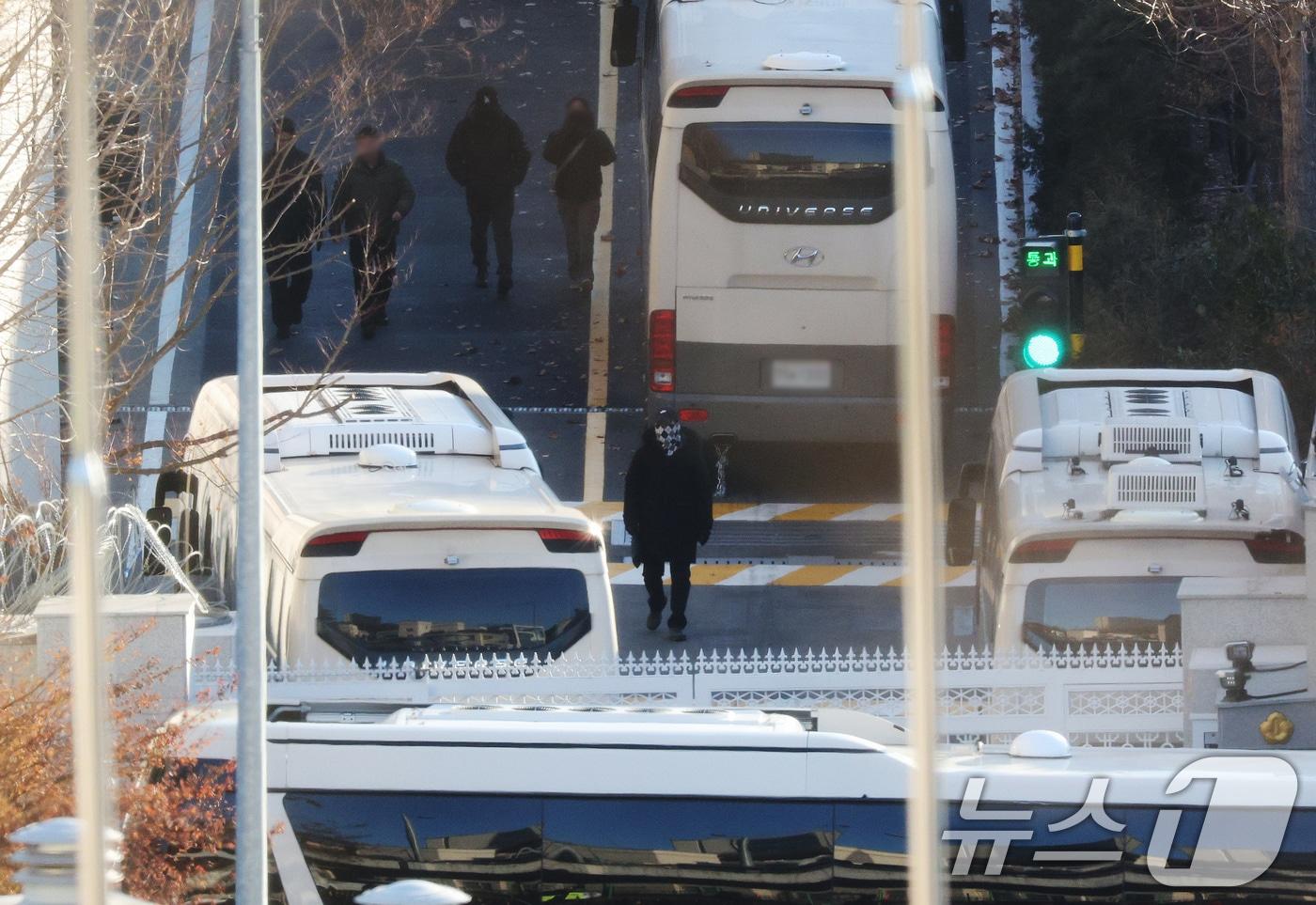 9일 오전 서울 용산구 한남동 대통령 관저에서 차벽을 세우기 위해 동원된 버스 차량 옆으로 경호처 등 관계자들이 이동하고 있다. 2025.1.9/뉴스1 ⓒ News1 장수영 기자