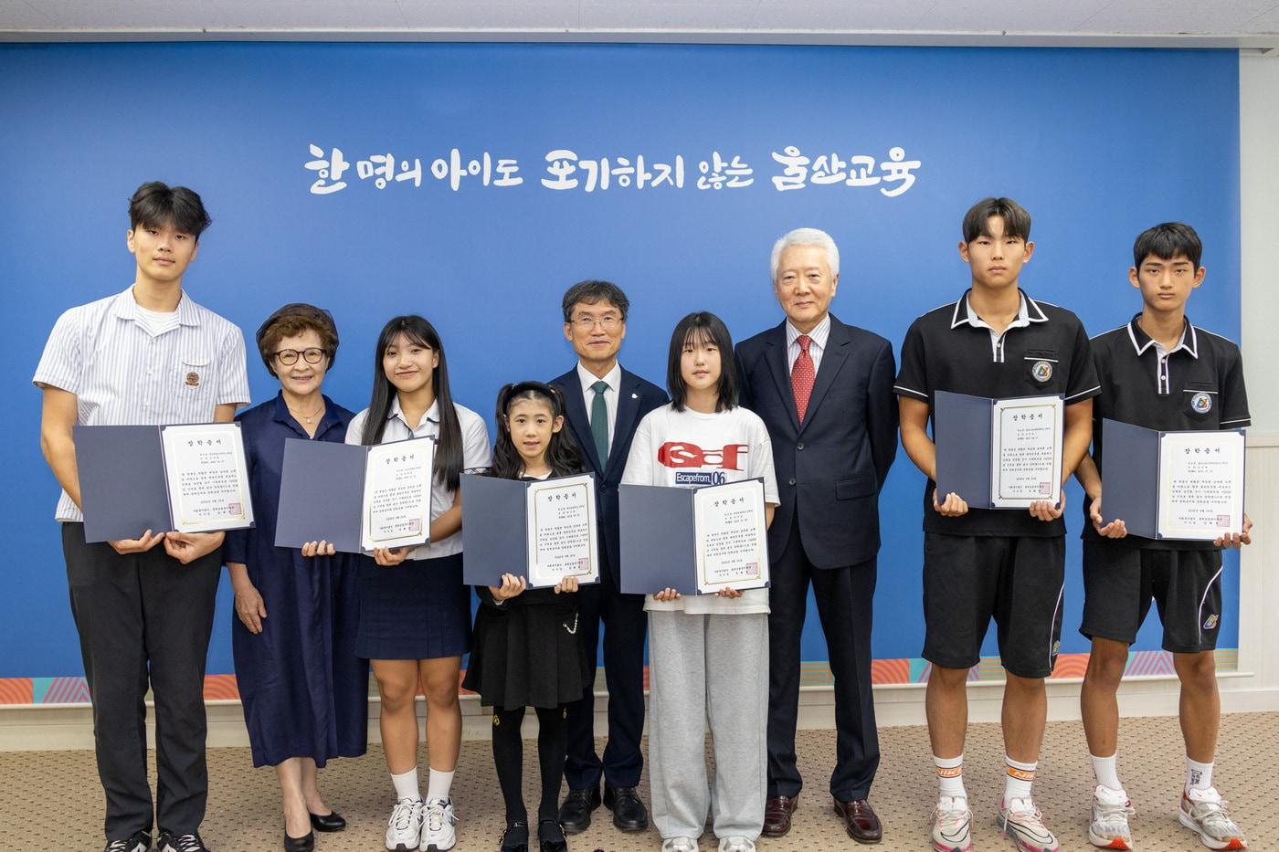 신혜승&#40;왼쪽에서 두 번째&#41;, 조돈영 롯데삼동복지재단 이사&#40;오른쪽에서 세 번째&#41;, 천창수 울산광역시교육감&#40;왼쪽에서 다섯 번째&#41;이 장학생들과 기념사진을 촬영하고 있다.&#40;롯데재단 제공&#41;. 