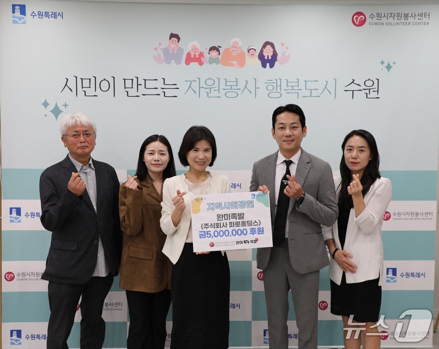 본문 이미지 - 완미족발 임직원, 수원시자원봉사센터 관계자들이 지난 29일 오전 센터에서 500만원 후원을 단체로 기념하고 있다. (수원시자원봉사센터 제공. 재판매 및 DB금지)