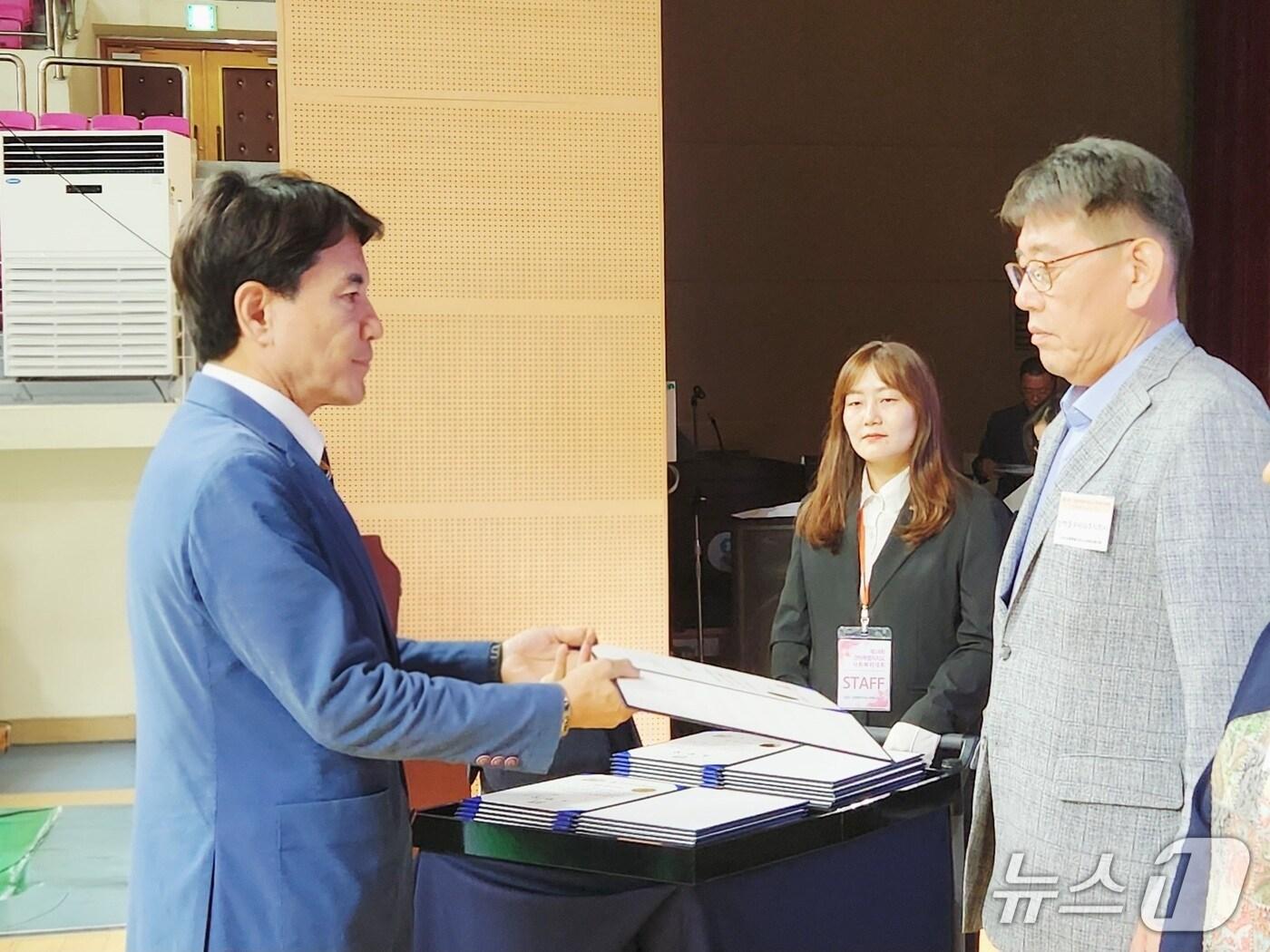 본문 이미지 - 지난달 30일 천천 호반체육관에서 열린 강원도 사회복지대회에서 최윤 삼척블루파워 발전운영실장&#40;사진 오른쪽&#41;이 김진태 강원도지사에게 표창을 받고 있다.&#40;삼척블루파워 제공, 재판매 및 DB 금지&#41; 2025.10.1/뉴스1