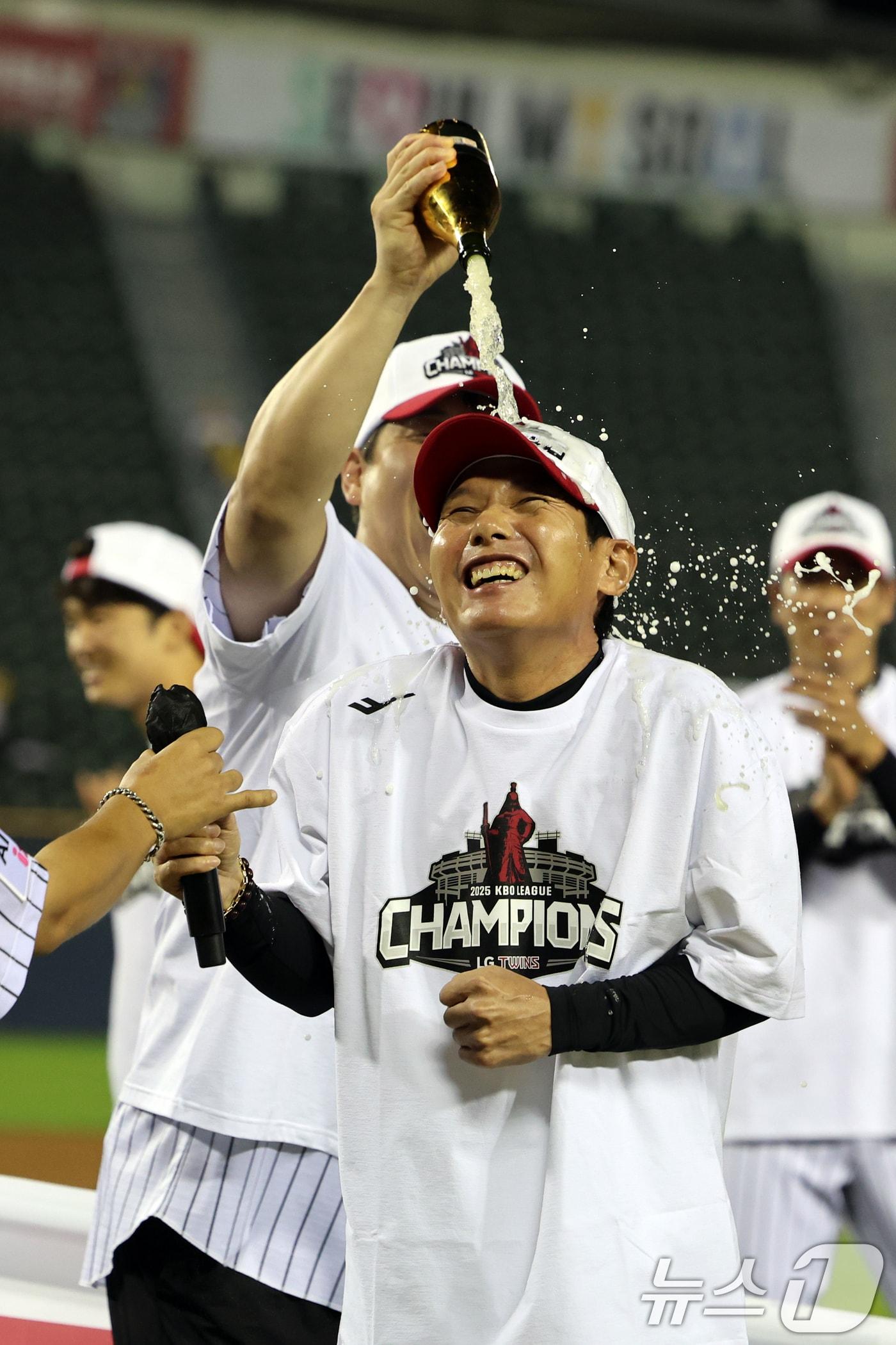 본문 이미지 - 2년 만에 프로야구 정규시즌 우승을 확정한 염경엽 LG 트윈스 감독이 1일 서울 송파구 잠실야구장에서 소감을 밝힌 후 샴페인 세례를 받고 있다. 2025.10.1/뉴스1 ⓒ News1 황기선 기자