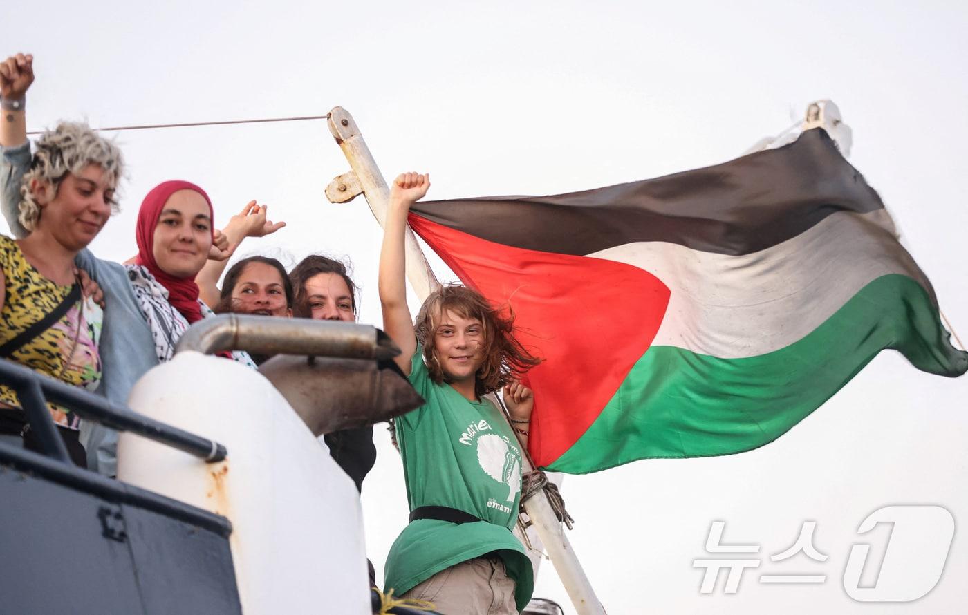 9월 25일&#40;현지시간&#41; 그리스 크레타섬 인근 해역에서 팔레스타인 가자지구로 향하던 &#39;글로벌 수무드 함대&#39;&#40;GSF&#41; 선박 위에서 그레타 툰베리&#40;오른쪽&#41;를 비롯한 활동가들이 승리를 뜻하는 손짓을 하고 있다. 2025.09.25. ⓒ 로이터=뉴스1 ⓒ News1 윤다정 기자