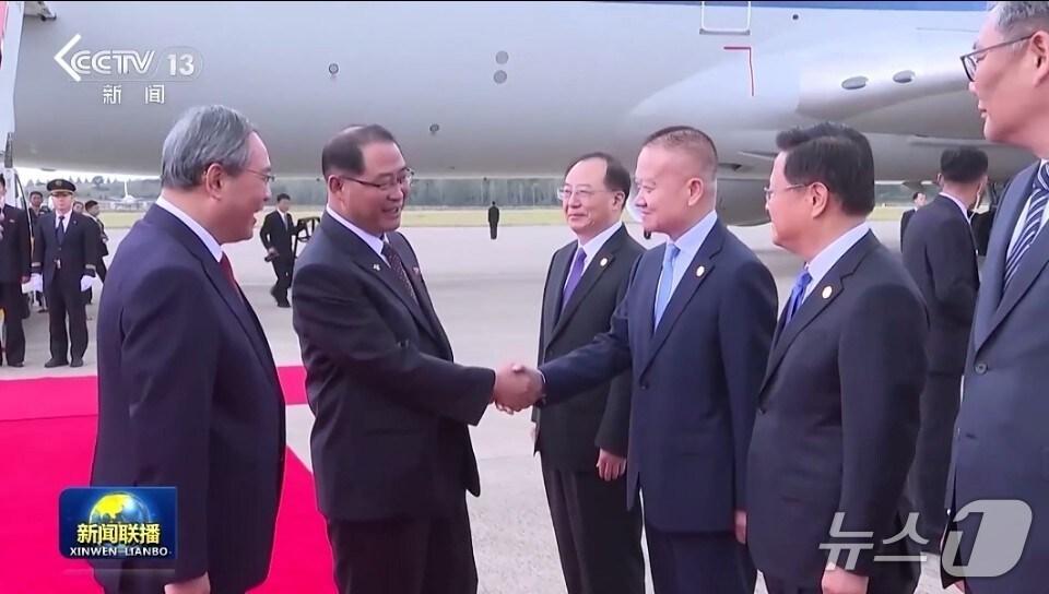 본문 이미지 - 박태성 북한 내각 총리&#40;왼쪽 두번째&#41;와 류하이싱 중국 대외연락부장이 9일 평양 공항에서 악수를 하고 있다. &#40;CCTV 갈무리&#41; 