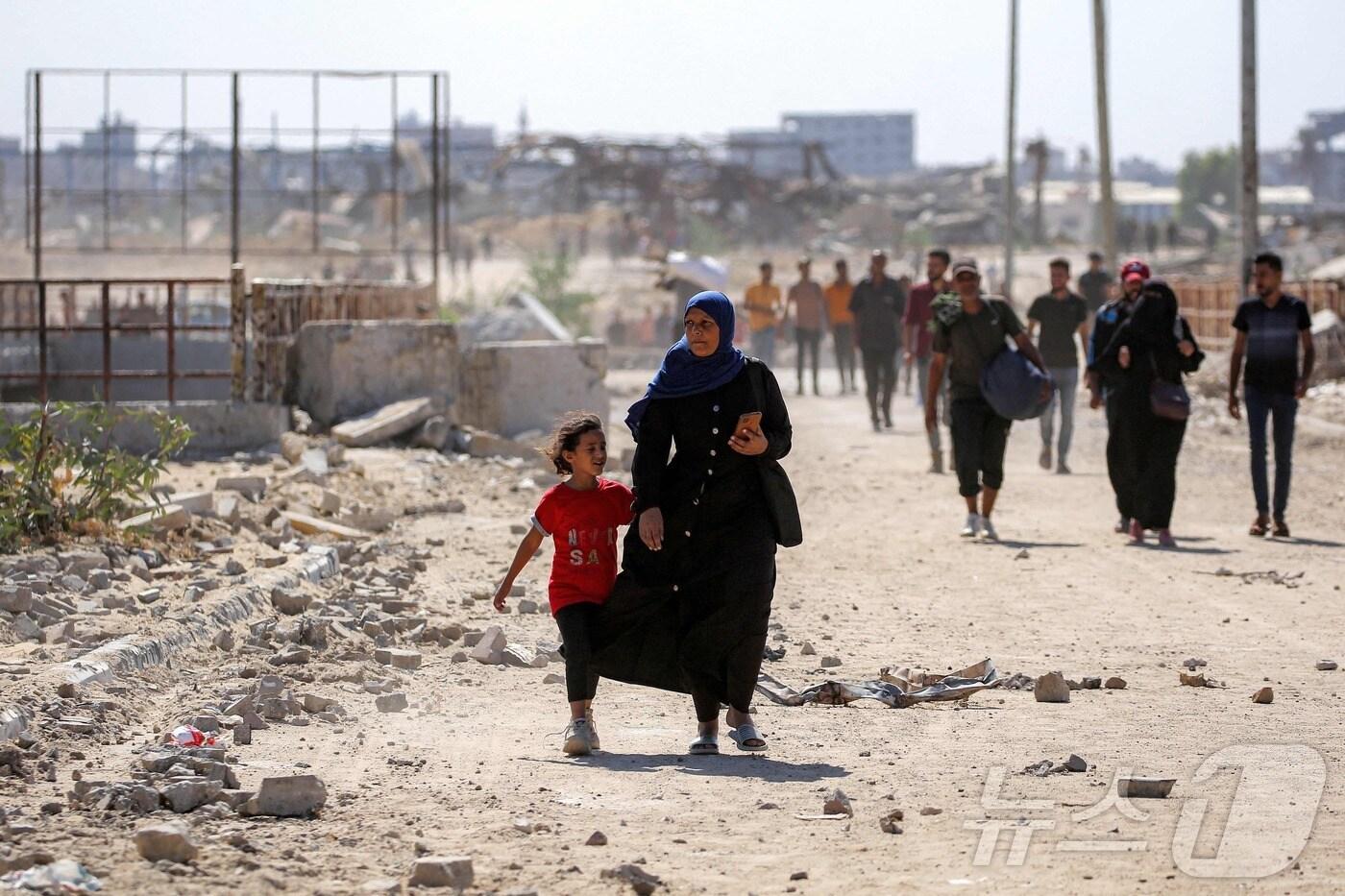 10일&#40;현지시간&#41; 가자지구 중부 누세이라트에서 가자시티로 향하는 길에서 한 여성이 한 소녀와 함께 걷고 있다. 2025. 10. 10. ⓒ AFP=뉴스1 ⓒ News1 양은하 기자