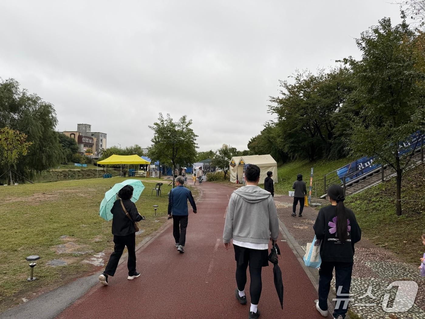 본문 이미지 - 11일 낮 강원 춘천 온의동 공지천 산책로 일대에서 열리는 재즈페스타를 구경하려는 시민들이 발걸음을 옮기고 있다.2025.10.11 한귀섭 기자