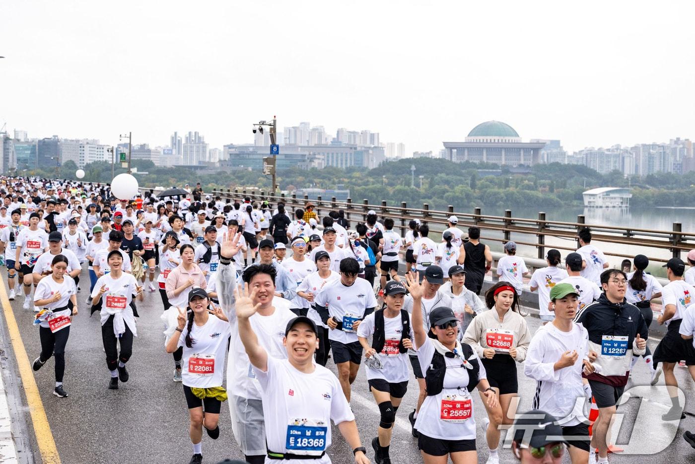 지난 11일 서울 여의도공원에서 열린 ‘디즈니런 서울 2025’ 행사에서 미키와 친구들과 주토피아 캐릭터로 디자인 된 공식 티셔츠를 착용한 참가자들이 서강대교를 달리고 있다. (디즈니코리아 제공. 재판매 및 DB 금지) 2025.10.12/뉴스1
