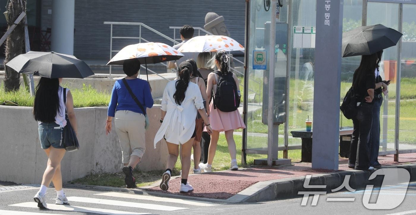 지난 12일 오후 제주시 용담 해안도로에서 양산과 반팔 차림을 한 관광객들이 제주의 풍광을 즐기고 있다.  2025.10.12/뉴스1 ⓒ News1 고동명 기자