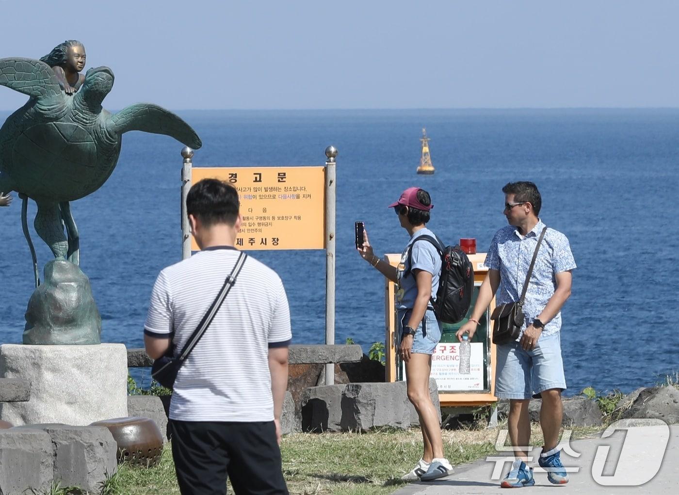 본문 이미지 - 12일 오후 반팔 차림을 한 관광객들이 제주시 용담해안도로를 걷고 있다. 제주는 10월에도 낮 기온이 29~30도의 무더운 날씨를 보이고 있다. 2025.10.12/뉴스1 ⓒ News1 고동명 기자