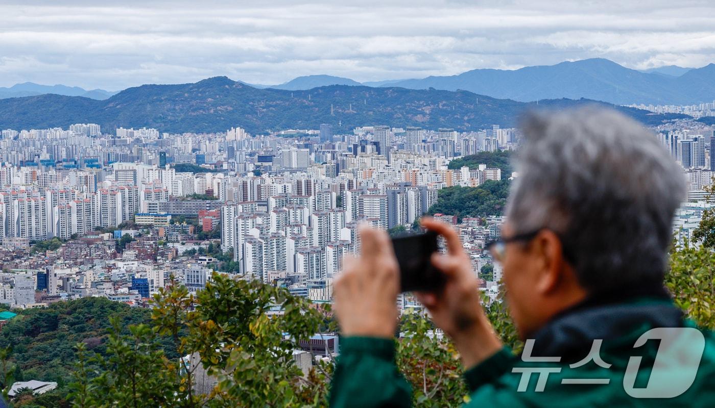 본문 이미지 - 서울 아파트값이 4주 연속 상승폭을 키우며 비규제지역 중심으로 과열 현상이 뚜렷해지고 있는 12일 서울 남산에서 관광객들이 도심 전경을 감상하고 있다. 2025.10.12/뉴스1 ⓒ News1 안은나 기자