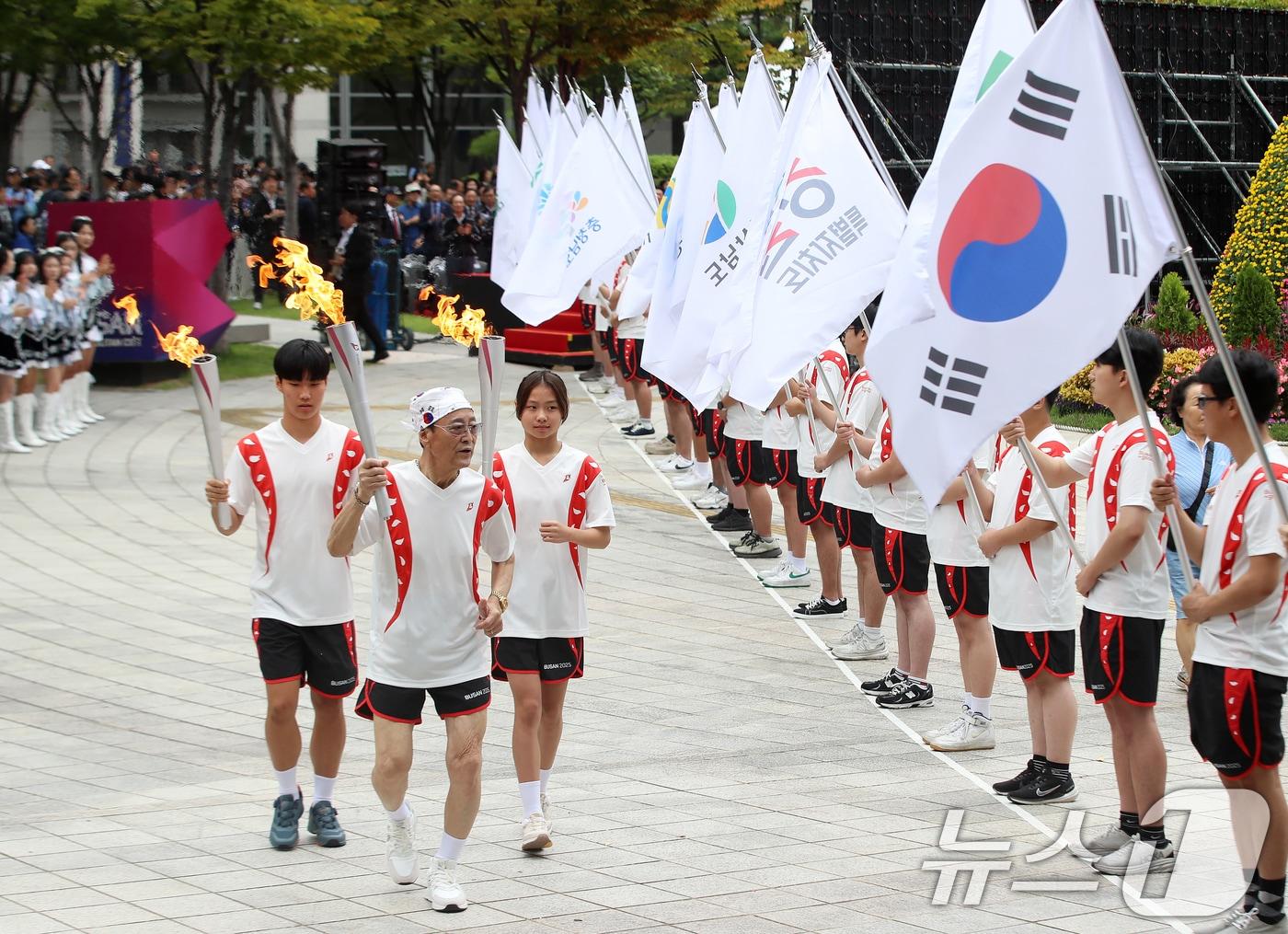 본문 이미지 - 13일 부산 연제구 부산시청 광장에서 열린 제106회 전국체육대회·제45회 전국장애인체육대회 성화 합화·출발식에서 성화 봉송 첫 주자들이 출발하고 있다. 2025.10.13/뉴스1 ⓒ News1 윤일지 기자