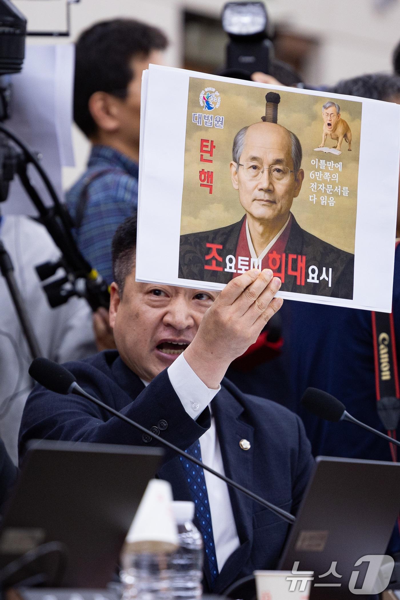 본문 이미지 - 최혁진 무소속 의원이 13일 서울 여의도 국회에서 열린 법제사법위원회의 대법원 등에 대한 국정감사에서 조희대 대법원장에게 질의하며 손팻말을 들어보이고 있다. 2025.10.13/뉴스1 ⓒ News1 유승관 기자