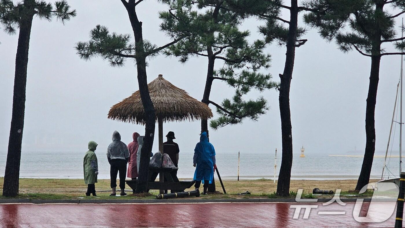 13일 경북 포항시 북구 영일대해수욕장 해변에서 시민들이 그늘막 아래에 모여 비를 피하고 있다. 2025.10.13/뉴스1 ⓒ News1 최창호 기자