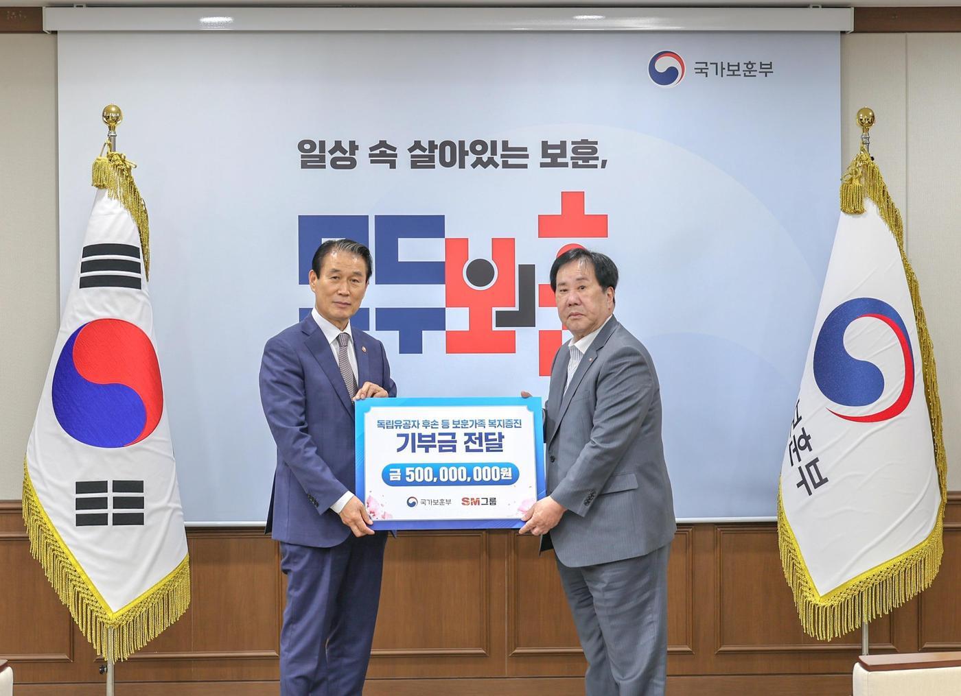 본문 이미지 - 우오현  SM그룹 회장&#40;오른쪽&#41;이 13일 오전 정부세종청사에서 열린 국가보훈부의 전 국민 보훈 기부 프로젝트 &#39;모두의 보훈 드림&#39; 후원금 전달식에서 권오을 장관과 기념촬영을 하고 있다.&#40;SM그룹 제공&#41;  뉴스1 ⓒ News1 