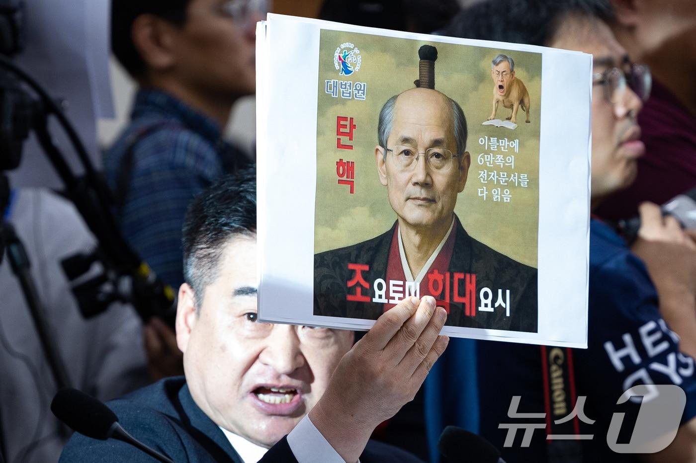 최혁진 무소속 의원이 13일 서울 여의도 국회에서 열린 법제사법위원회의 대법원 등에 대한 국정감사에서 조희대 대법원장에게 질의하며 손팻말을 들어보이고 있다. 2025.10.13/뉴스1 ⓒ News1 유승관 기자