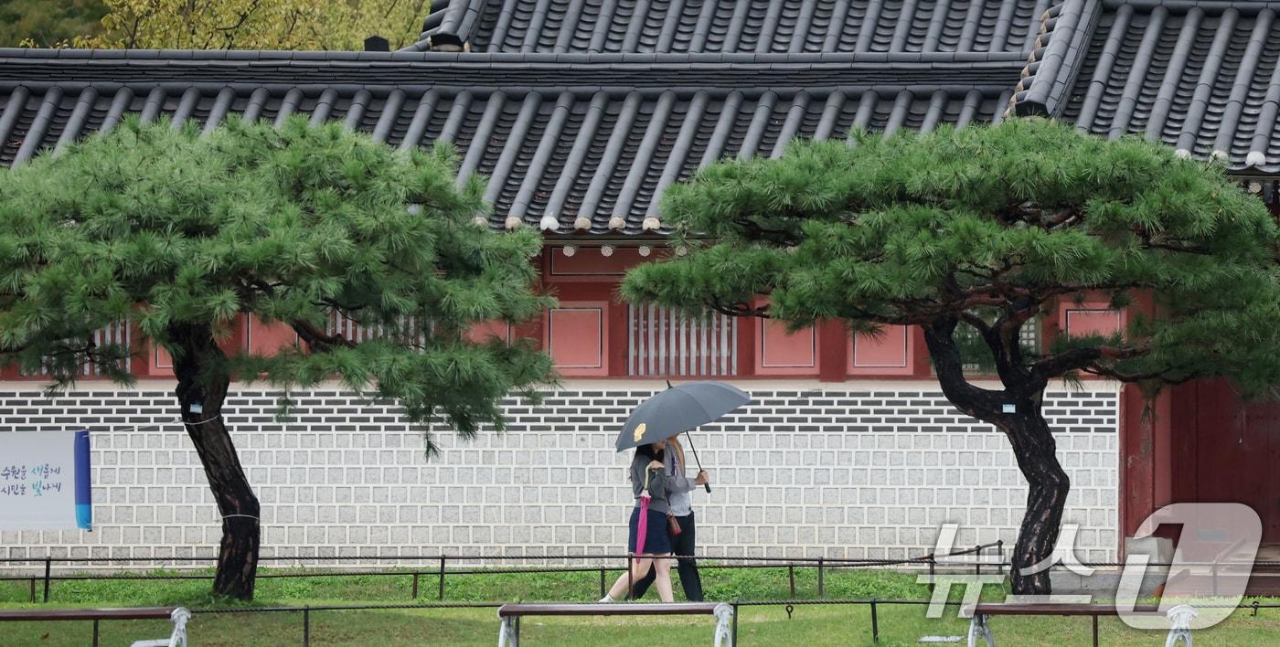 수도권에 곳곳에 비가 내리고 있는 13일 경기 수원시 팔달구 수원화성 화성행궁 인근에서 시민들이 우산을 쓰고 걸어가고 있다. 2025.10.13/뉴스1 ⓒ News1 김영운 기자