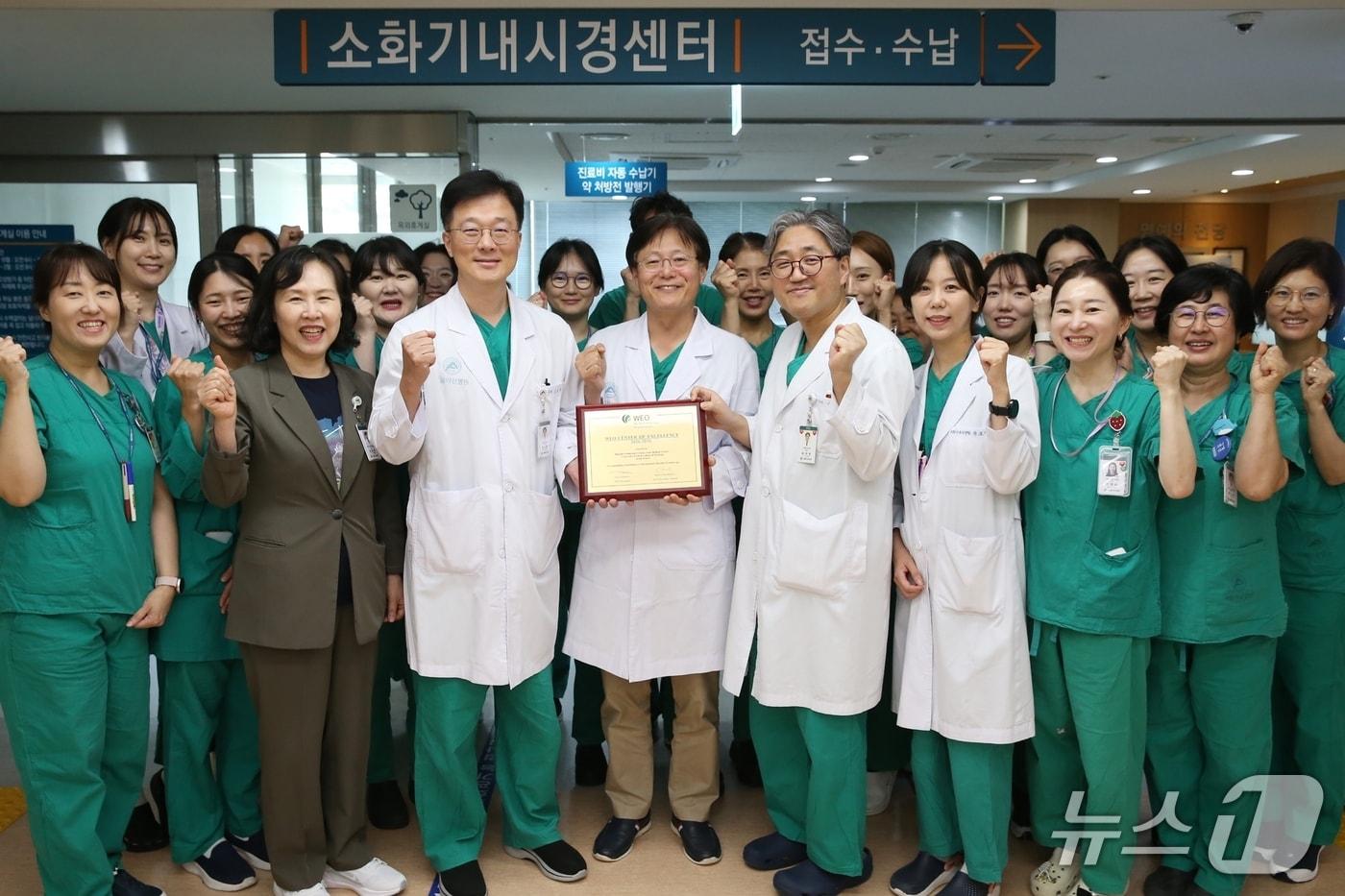 서울아산병원 소화기내시경센터 의료진이 세계내시경협회 '최우수 내시경센터' 인증패를 들고 기념촬영을 하고 있다.(서울아산병원 제공)