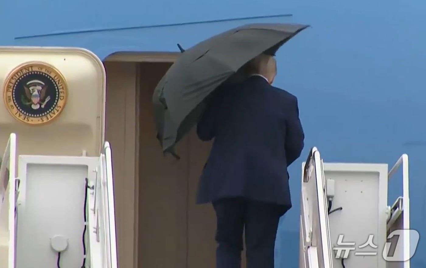 도널드 트럼프 미국 대통령이 12일(현지시간) 이스라엘로 출발하는 에어포스원에 탑승하기 전 우산을 접지 못하는 모습이 포착됐다. 2025.10.13./뉴스1