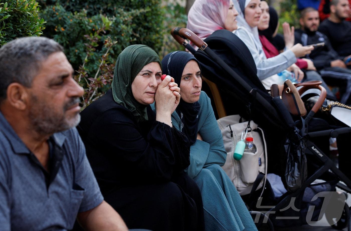 13일&#40;현지시간&#41; 하마스와 이스라엘 간 인질-수감자 교환 및 휴전 협정의 일환으로 팔레스타인 수감자들이 이스라엘 감옥에서 풀려나자 이스라엘이 점령한 요르단강 서안지구 라말라에서 가족들이 친족을 기다리고 있다. 2025.10.13. ⓒ 로이터=뉴스1 ⓒ News1 이정환 기자
