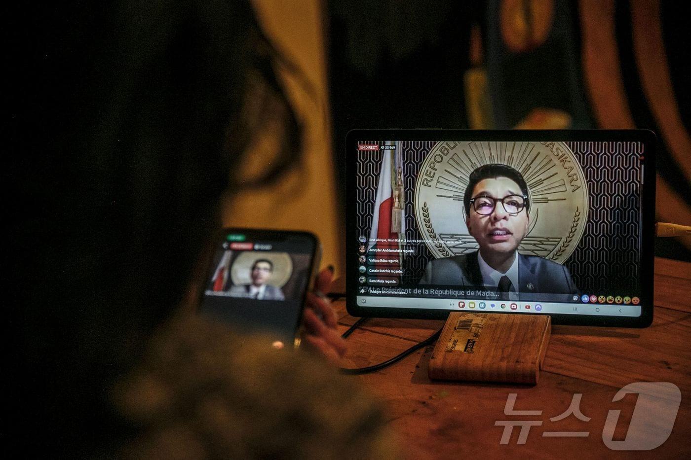 13일&#40;현지시간&#41; 마다가스카르 수도 안타나나리보의 한 주민이 자택에서 마다가스카르 대통령 안드리 라조엘리나의 대국민 연설을 대통령실 공식 페이스북 페이지를 통해 시청하고 있다. 라조엘리나 대통령은 프랑스 군용기를 타고 해외 도피했다. 사임 요구가 거세지는 가운데 실종 상태였던 라조엘리나 대통령의 연설은 많은 관심을 모았으나, 무장 군인들이 국영 방송 장악을 시도하면서 두 차례나 지연됐다.ⓒ AFP=뉴스1