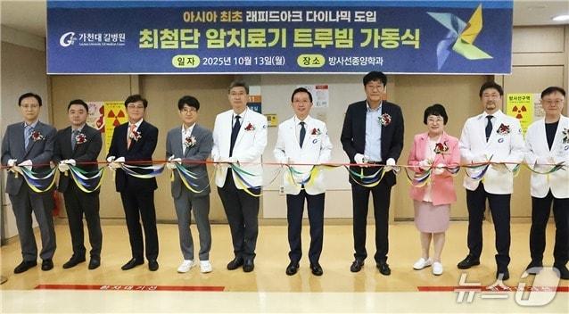 본문 이미지 - 13일 가천대 길병원에서 개최된 '최첨단 방사선 치료기 트루빔의 가동식'에서 김우경 병원장(사진 왼쪽에서 여섯 번째)과 신병철 인천시 복지국장(오른쪽에서 네 번째) 등 참석자들이 기념 테이프를 자르고 있다.