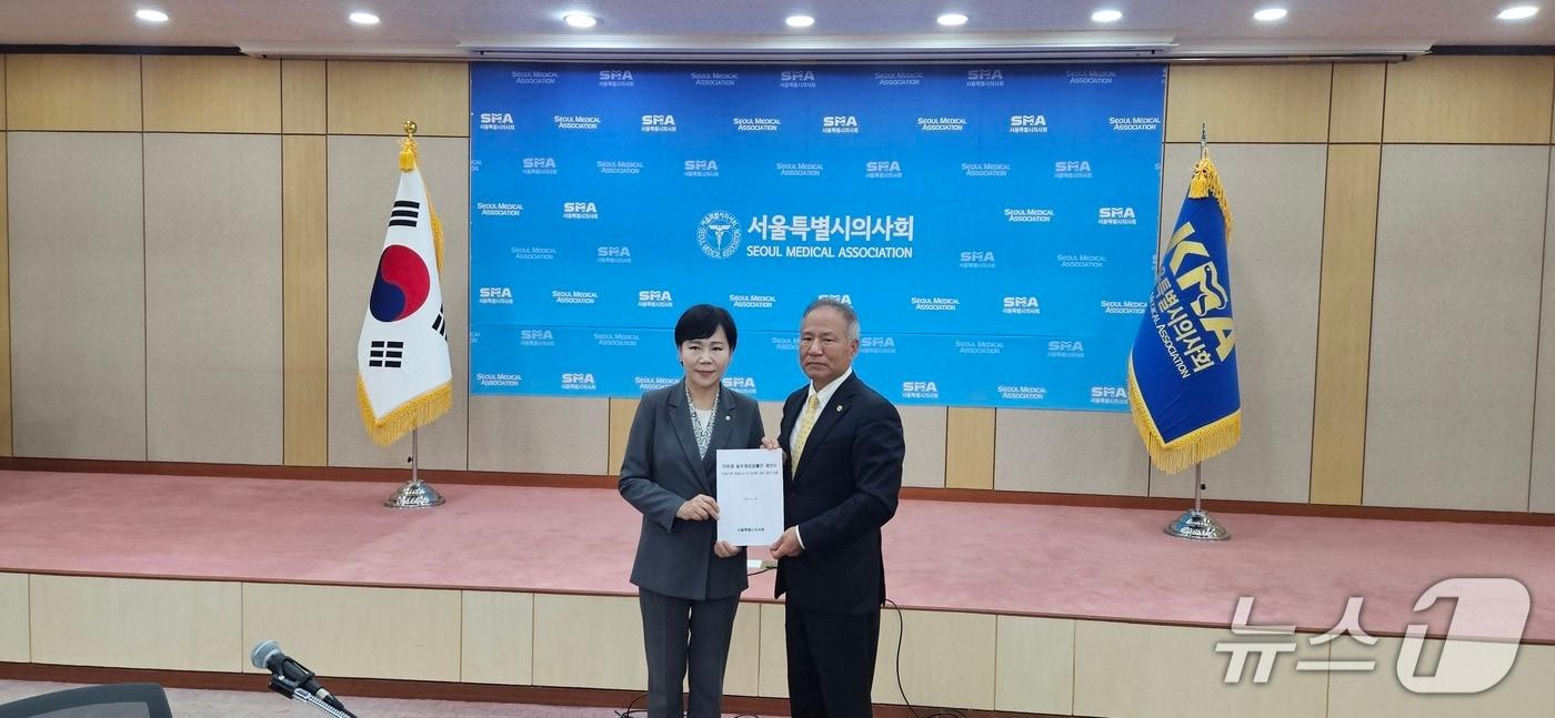 14일 서울 영등포구 서울시의사회관에서 황규석 서울시의사회장&#40;오른쪽&#41;이 전현희 더불어민주당 수석최고위원에게 &#39;의료법 개정안 제안서&#39;를 전달하고 있다./뉴스1