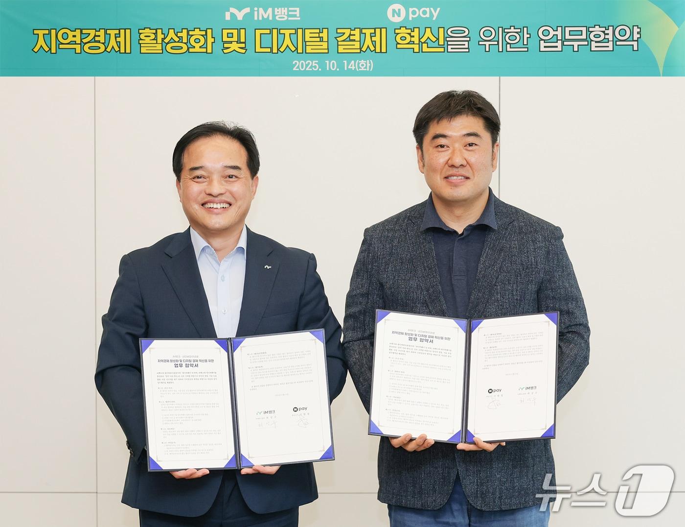 본문 이미지 - 최상수 iM뱅크 마케팅그룹장&#40;왼쪽&#41;과 이향철 네이버페이 책임리더가 소상공인 결제 및 지역화폐 디지털 혁신을 위한 전략적 업무협약을 체결한 뒤 협약서를 펼쳐 보이고 있다.&#40;iM뱅크 제공, 재판매 및 DB 금지&#41;