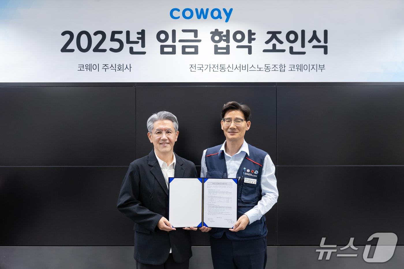 서장원 코웨이 대표(왼쪽)와 임창경 코웨이지부 지부장이 '2025년 임금 협약'을 체결한 뒤 기념촬영을 하고 있다.(코웨이 제공)