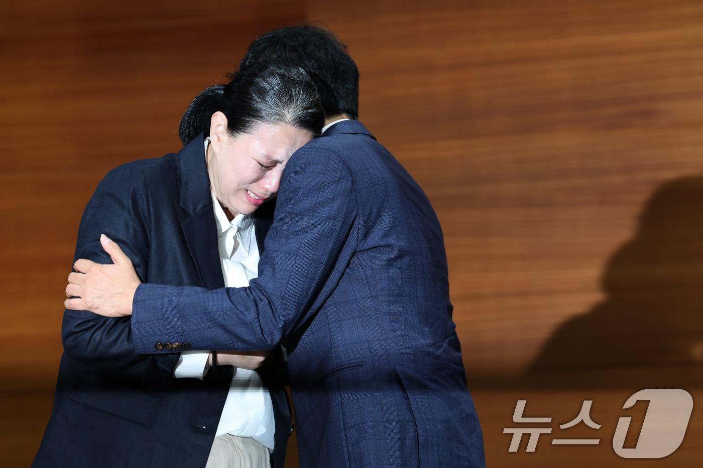 직장 내 괴롭힘을 호소하며 스스로 목숨을 끊은 MBC 기상캐스터 오요안나 씨의 어머니 장연미 씨가 15일 오전 서울시 마포구 상암동 MBC 상암사옥 골든마우스홀에서 열린 MBC-고 오요안나 유족 기자회견에서 안형준 MBC 사장에게 받은 고인의 명예 사원증을 품에 안은 채 오열하고 있다. 2025.10.15/뉴스1 ⓒ News1 박정호 기자