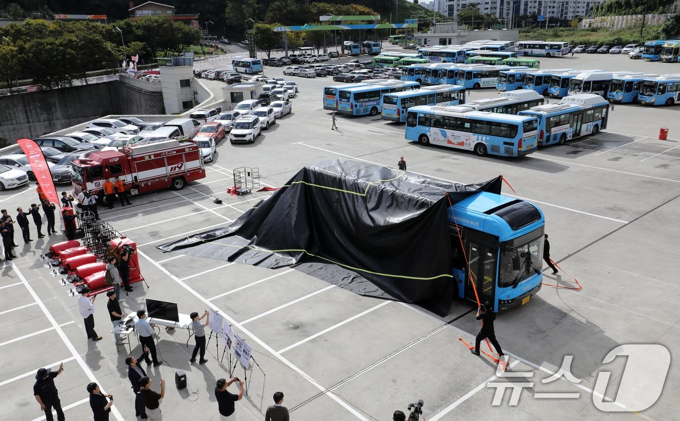 15일 부산 연제구 연제공용시내버스차고지에서 열린 전기버스 화재 초동조치 시스템 시연회에서 부산버스조합 관계자들이 질식포를 덮고 있다.&#40;자료사진&#41;2025.10.15/뉴스1 ⓒ News1 윤일지 기자