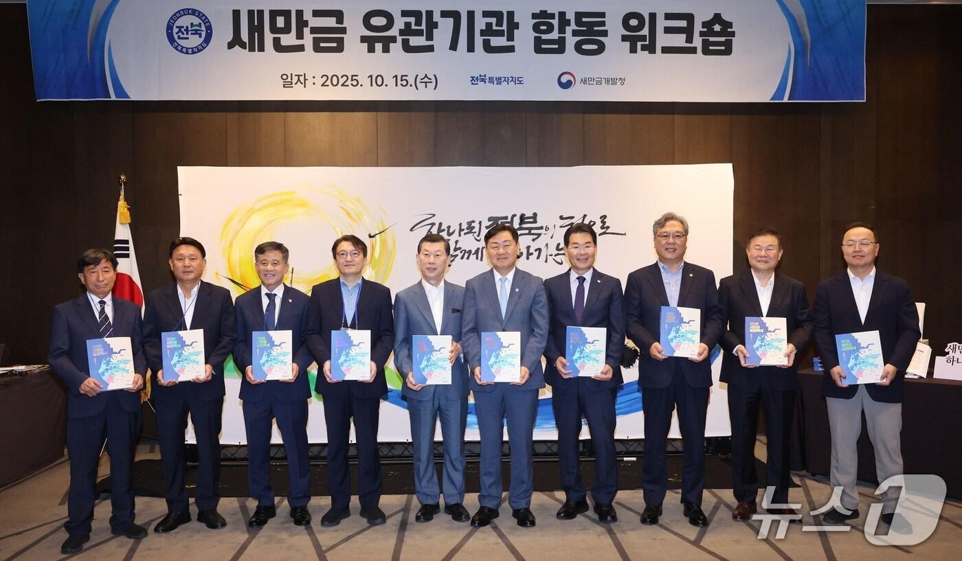 15일 전북 군산시 라마다호텔에서 &#39;2025 새만금 유관기관 합동 워크숍&#39;이 개최된 가운데 참석자들이 &#39;새만금 30년사&#39; 백서를 들고 기념 촬영을 하고 있다.&#40;전북도 제공. 재판매 및 DB금지&#41;/뉴스1