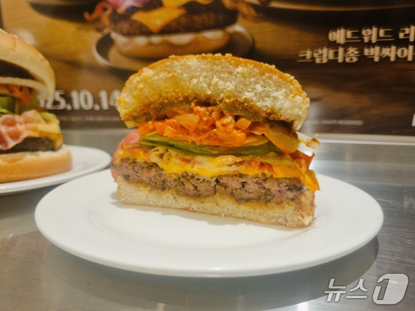 본문 이미지 - 맘스터치가 15일 서울 맘스터치LAB DDP점에서 에드워드 리 셰프와 협업한 2차 컬렉션 신제품 '에드워드 리 K 비프버거'를 선보이고 있다. 2025.10.15/ 뉴스1  박혜연 기자 ⓒ News1