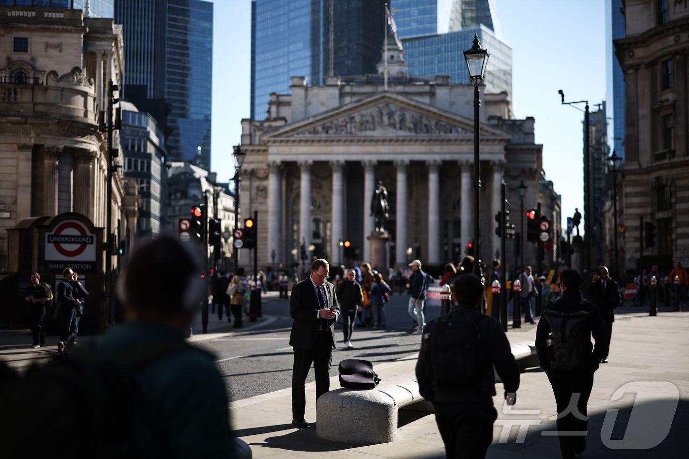 4월 7일(현지시간) 영국 런던 뱅크 지하철역 인근에서 한 남성이 휴대전화를 보고 있다. 2025.04.07. ⓒ AFP=뉴스1 ⓒ News1 윤다정 기자