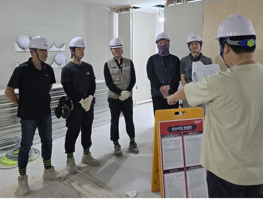 본문 이미지 -  오스템임플란트 인테리어 시공팀이 현장 작업 전 안전 교육을 하는 모습. &#40;오스템임플란트 제공&#41;
