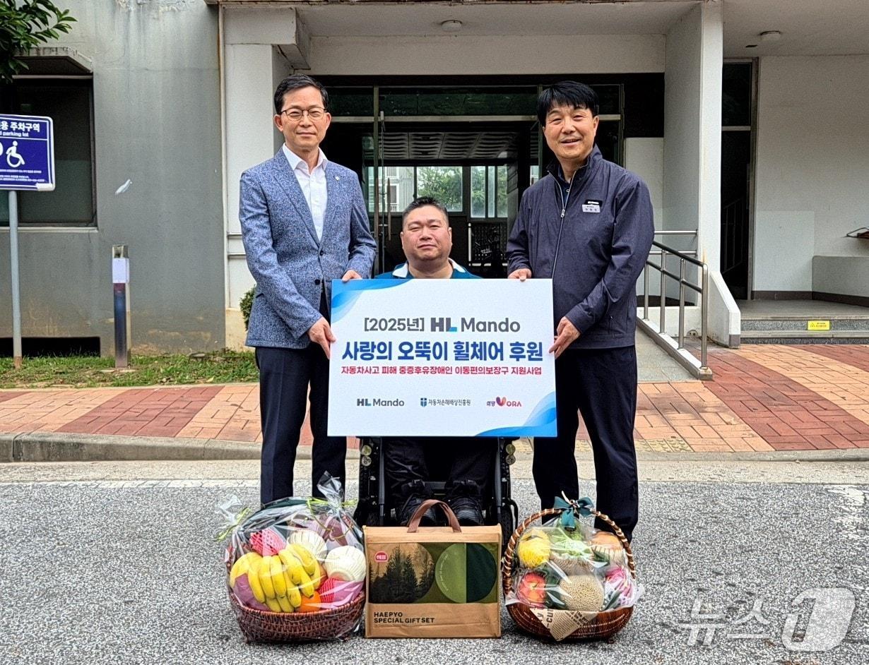 본문 이미지 - 전북 익산시 인근에 거주하는 수혜자 자택을 방문하여 '사랑의 오뚝이 휠체어' 기증식을 가졌다. 자동차손해배상진흥원 신세계 본부장(왼쪽), HL만도 신성호 상무.(HL만도 제공)