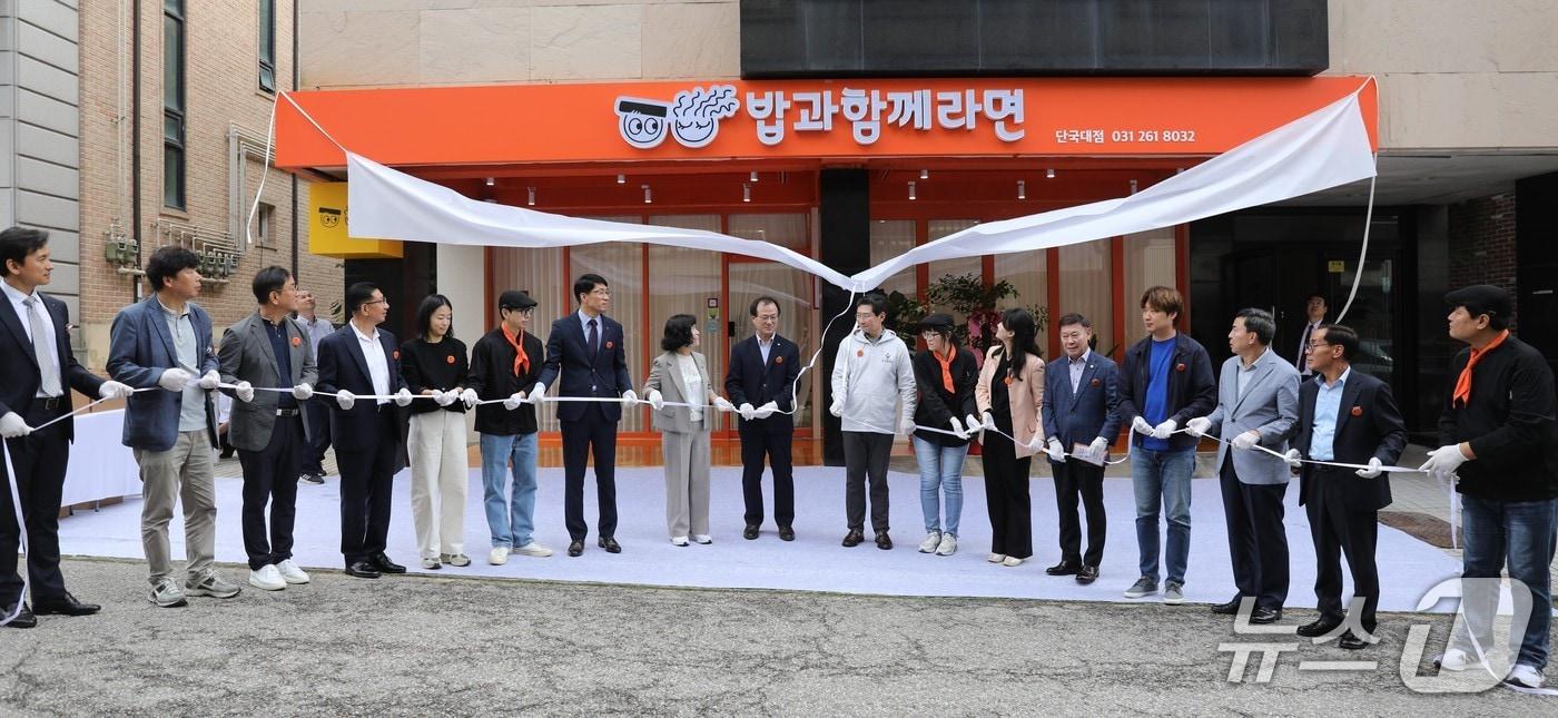 16일 진행된 ‘밥과함께라면’ 4호점 개소식에서 참석자들이 간판 제막식을 하고 있는 모습.&#40;용인YMCA 제공&#41;