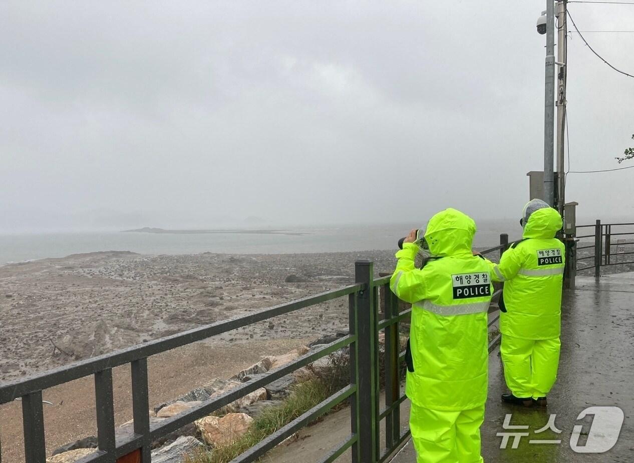 본문 이미지 - 평택해경 소속 파출소 경찰관이 우천 속 해안가를 순찰하고 있다.&#40;평택해경 제공&#41;