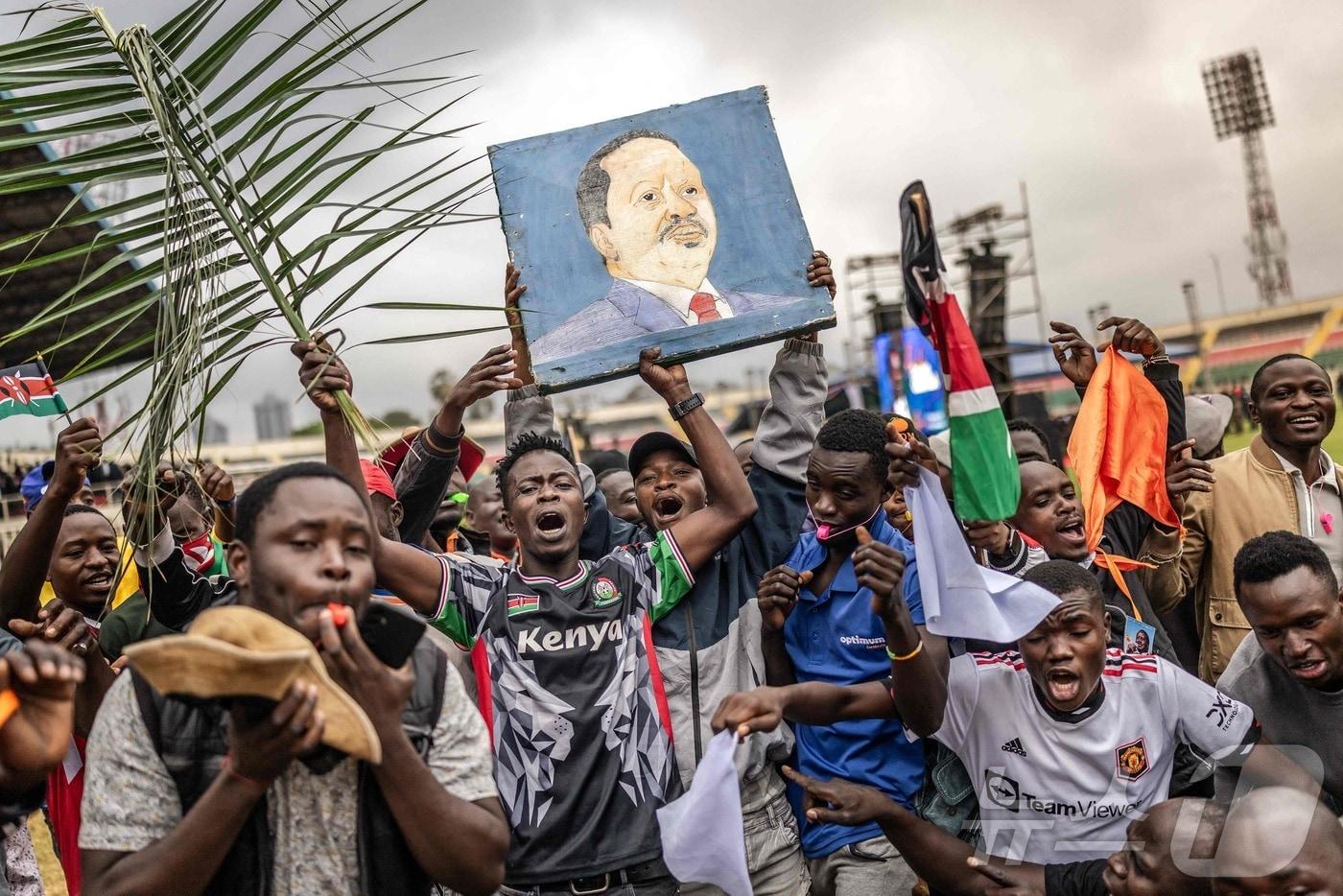 케냐 야당 지도자이자 전 총리인 라일라 오딩가의 조문객과 지지자들이17일&#40;현지시간&#41; 나이로비 냐요 스타디움에서 열리는 장례식을 앞두고 모인 자리에서 구호를 외치고 그의 초상화를 들고 있다. 2025.10.17 ⓒ AFP=뉴스1 ⓒNews1 이정환 기자