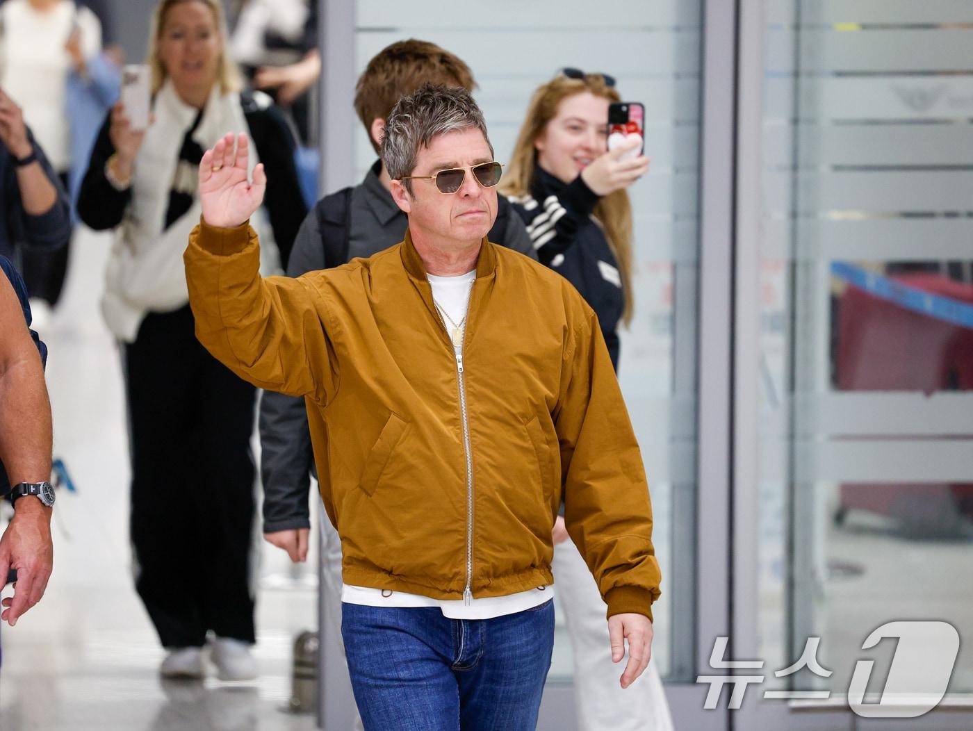 본문 이미지 - 16년 만의 내한 공연을 앞둔 밴드 오아시스(Oasis)의 노엘 갤러거(Noel Gallagher)가 19일 오후 인천국제공항 2터미널을 통해 입국하며 팬들을 향해 인사하고 있다. 2025.10.19/뉴스1 ⓒ News1 안은나 기자